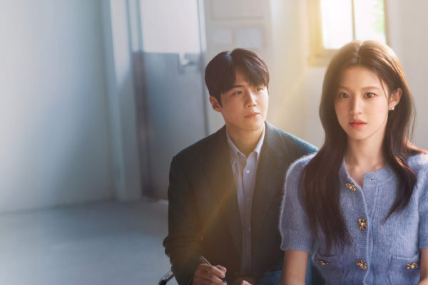 Imagem promocional de doramas novos janeiro, mostrando um homem sentado atrás de uma mulher em um ambiente iluminado por luz natural, ambos com expressão séria, sugerindo um romance dramático contemporâneo.