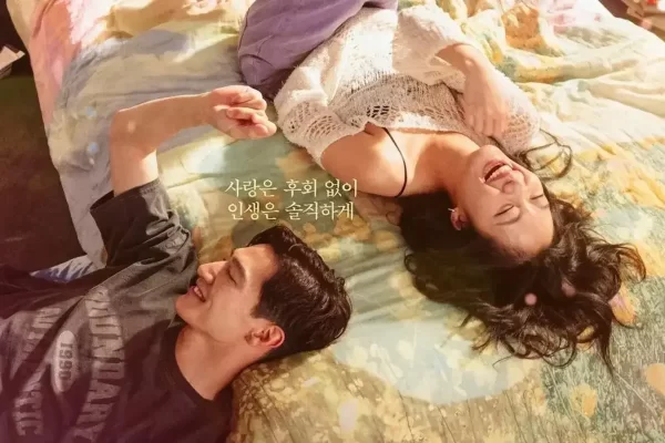 Cena de Regras do Amor na Cidade Grande: Kim Go-eun e Steve Sanghyun Noh em cena do filme Regras do Amor na Cidade Grande. Os dois aparecem deitados lado a lado sobre uma cama, sorrindo e conversando em um momento descontraído.